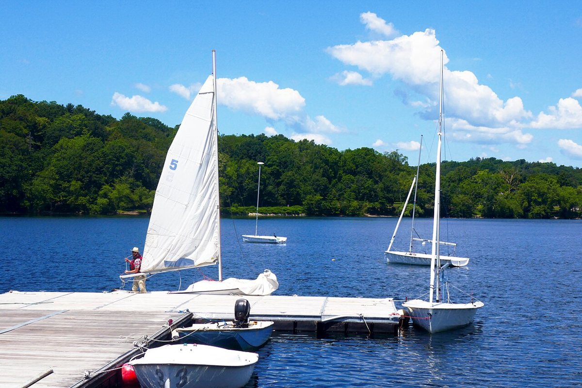 sailboats on Jamaica Pond with the tree-lined shoreline path in Jamaica Plain